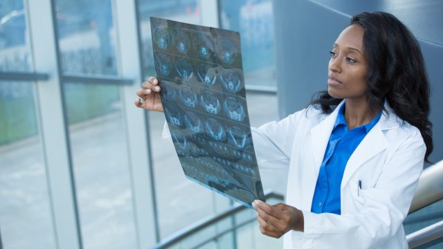 Young doctor holding scans