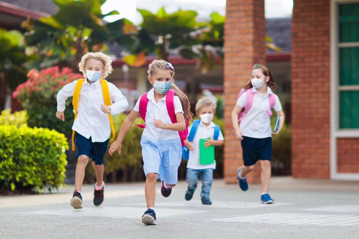 Kids in masks running through school yard