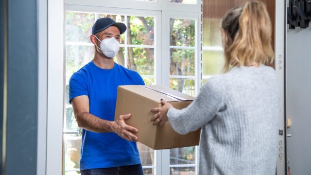 Man delivering package to woman at front door
