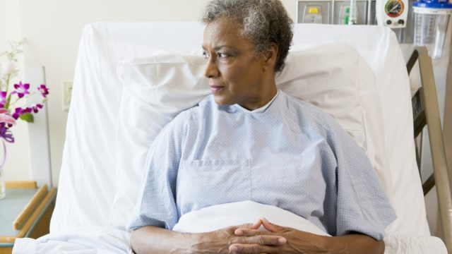 Senior black woman sitting in hospital bed