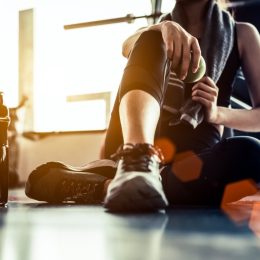 Woman sitting on gym floor after working out
