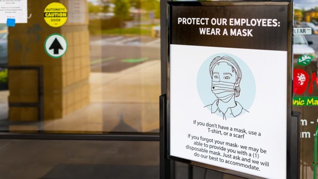 sign in front of supermarket indicating that coronavirus masks are required