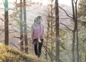 Portrait of sporty woman wearing a medical protection face mask while walking in the forest. Corona virus, or Covid-19, is spreading all over the world.