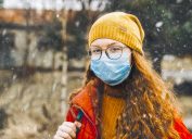 Teenage girl wearing protective mask for school during medical crisis of epidemic virus spreading covid 19