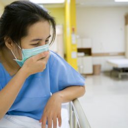 Woman with the flu in hospital wearing mask
