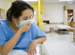 Woman with the flu in hospital wearing mask
