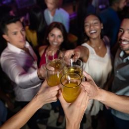 a group of multi ethnic friends makes a toast on the dance floor of a crowded nightclub