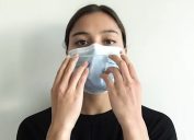 woman putting a mask on her face