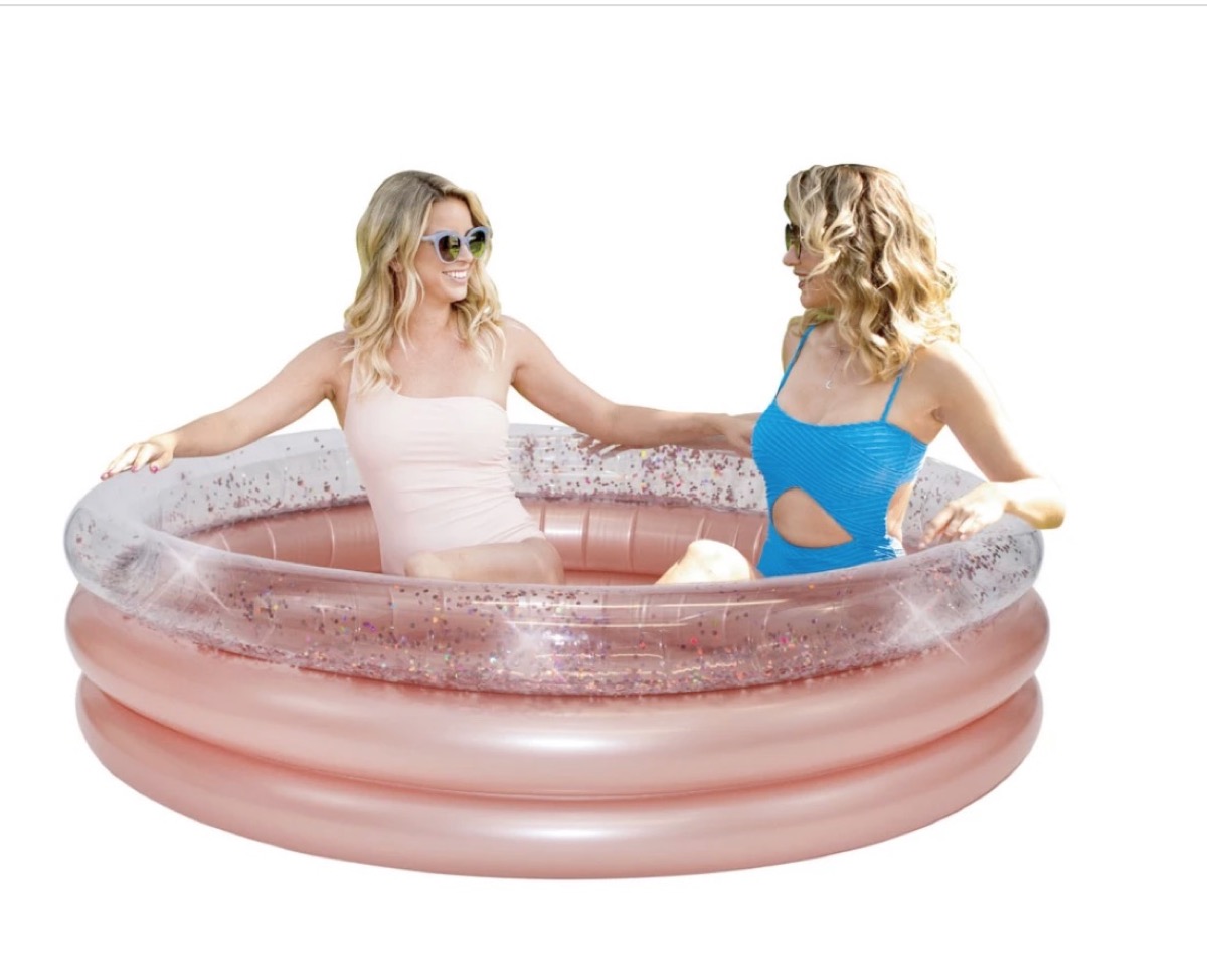two white blonde women in pink glitter pool