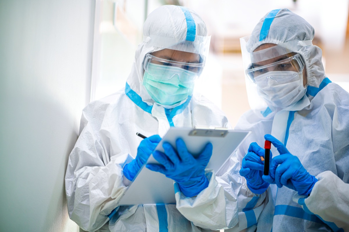 two asian researchers holding blood vial