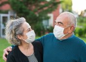 senior couple Couple wear surgical masks and smiling at each other