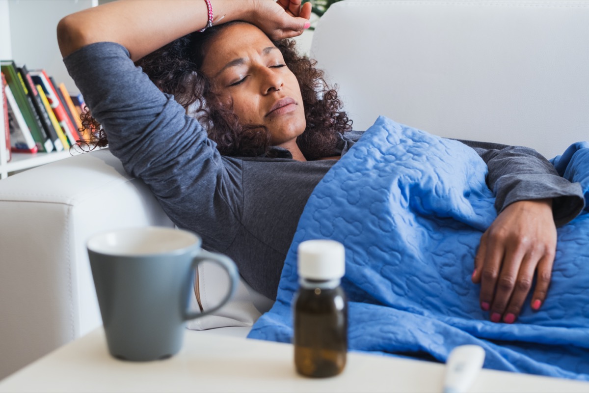 30 something woman sick at home on couch