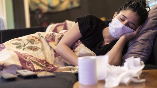One woman infected with virus and sick. sleeping in home, using face mask, handkerchief and toilet paper on table