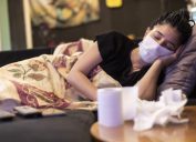 One woman infected with virus and sick. sleeping in home, using face mask, handkerchief and toilet paper on table