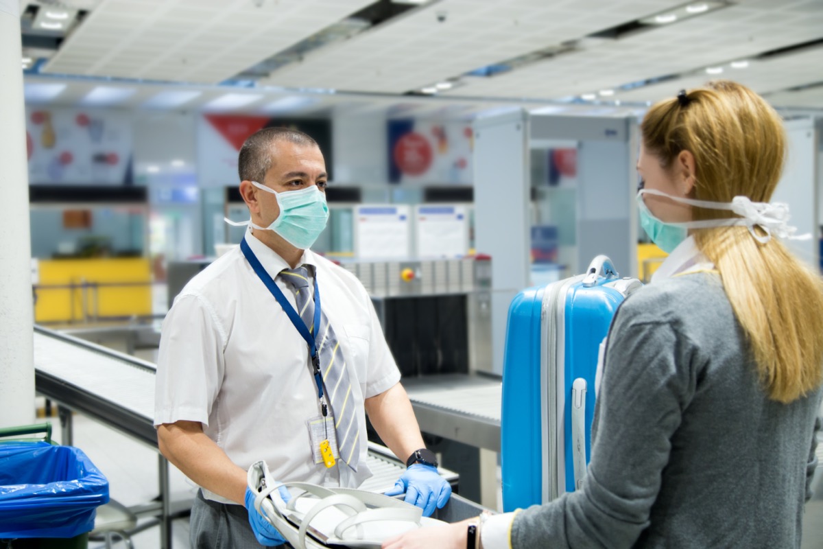 white woman wearing mask at airport security