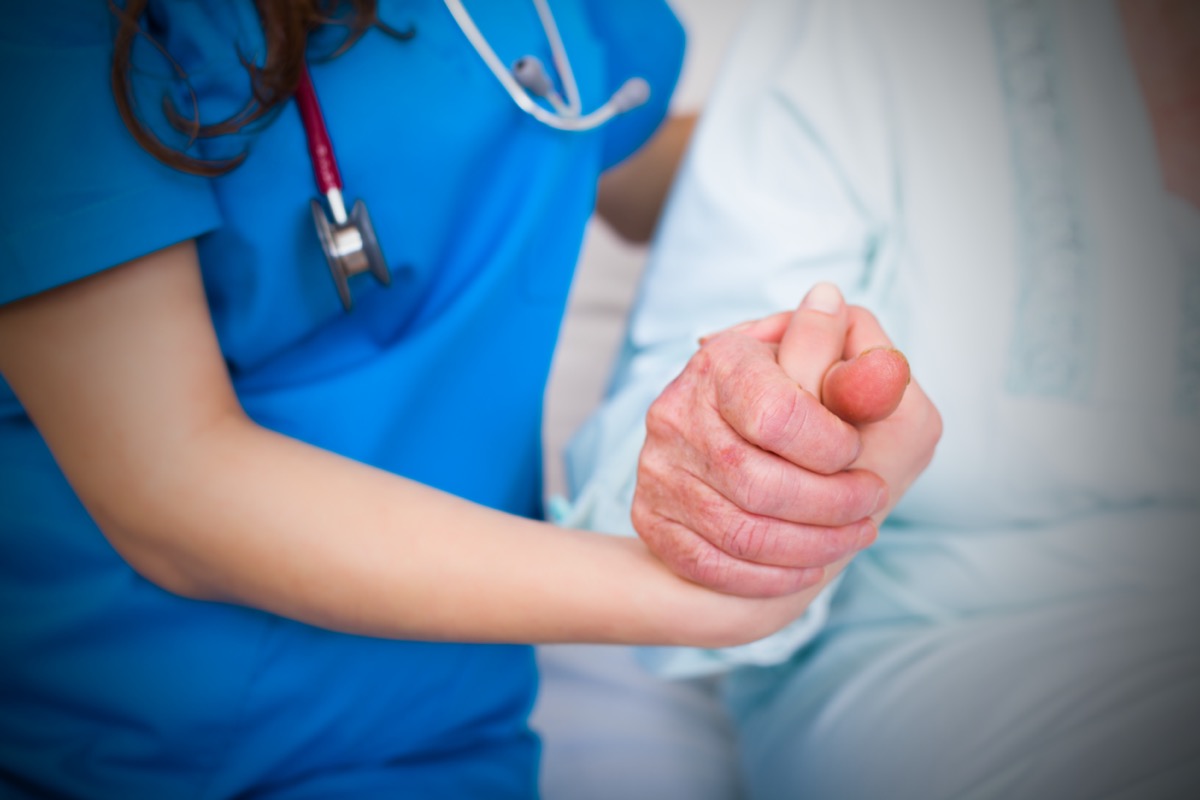 Doctor holding elderly patient's hand