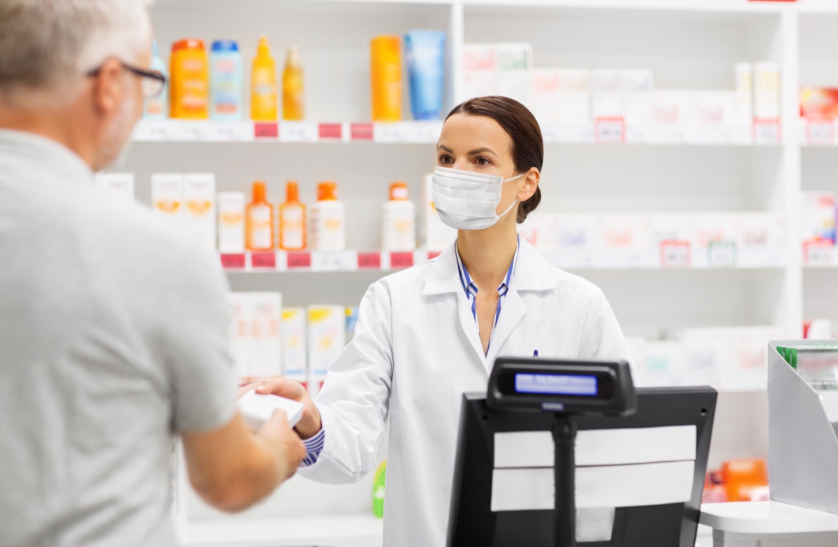 Man buying something from pharmacist with mask
