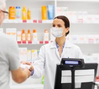 Man buying something from pharmacist with mask on