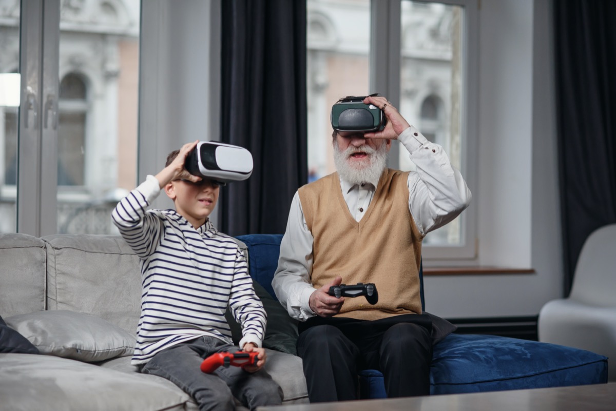 Senior man and boy playing virtual reality game