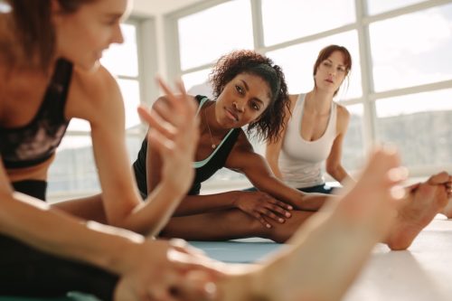 Women stretching and talking before workout class
