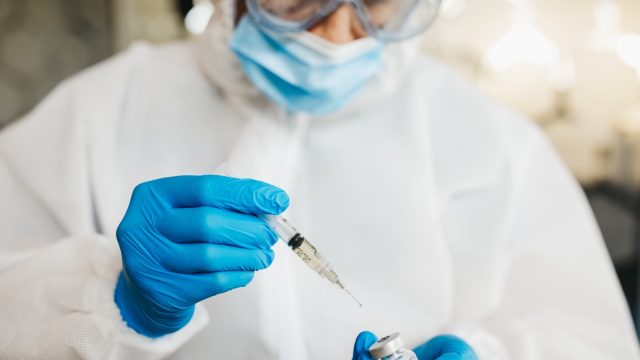 Doctor in protective suit work on vaccine against covid19 virus