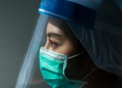 doctor looks stressed in mask and face shield amid coronavirus