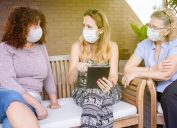 white women talking outdoors wearing coronavirus masks