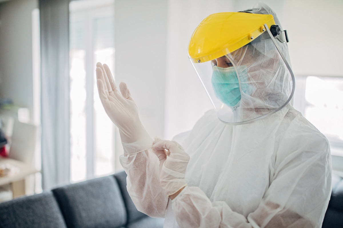 One woman, female doctor in full protective suit in home inspection.