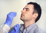 A Caucasian man has his nose swabbed for a coronavirus test