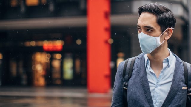 Gentleman with in coronavirus infected city wearing a pollution mask