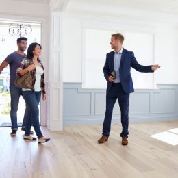 real estate agent showing home to young couple
