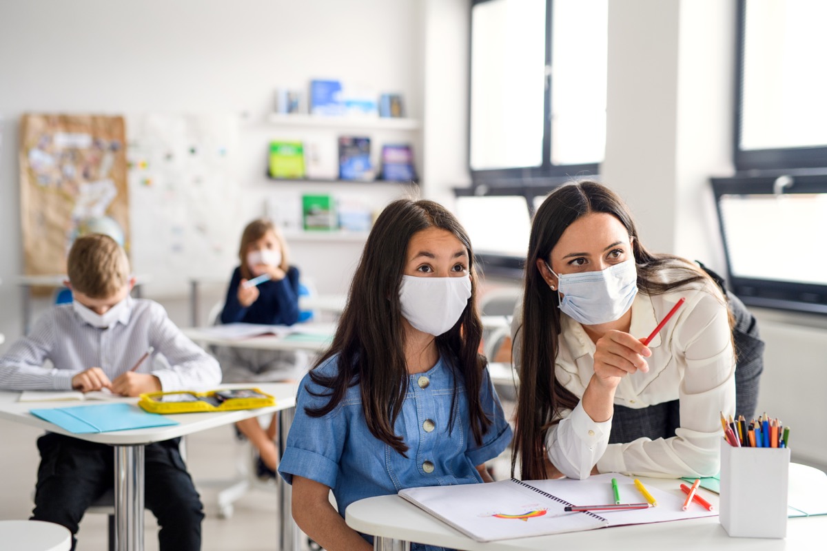 Teacher and students wearing masks during coronavirus pandemic back to school