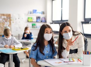 Teacher and students wearing masks during coronavirus pandemic back to school