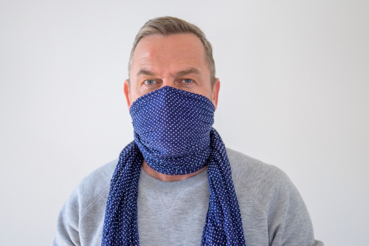 older wearing scarf as face covering