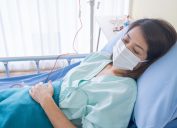 asian woman with face mask in hospital bed