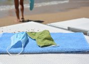 close up of face masks on a beach towel at the beach