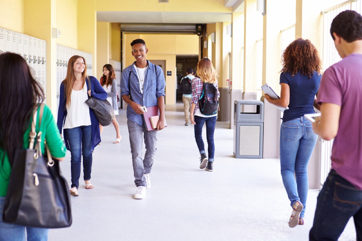 high school students walking down a school hallway