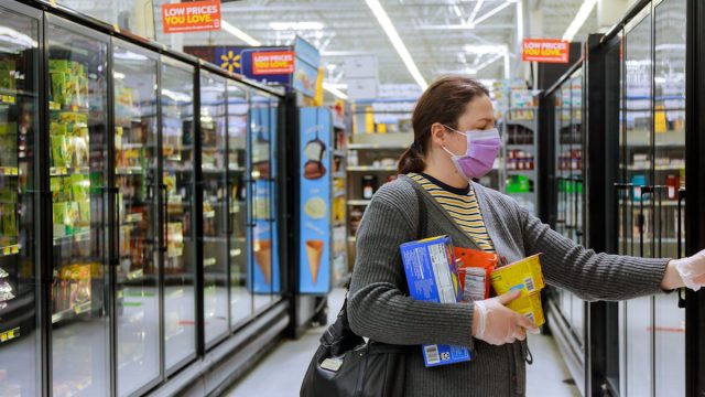 woman wearing mask at walmart while shopping in frozen food aisle