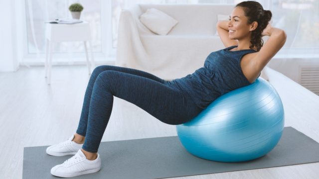 young black woman doing crunches on exercise ball