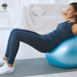 young black woman doing crunches on exercise ball