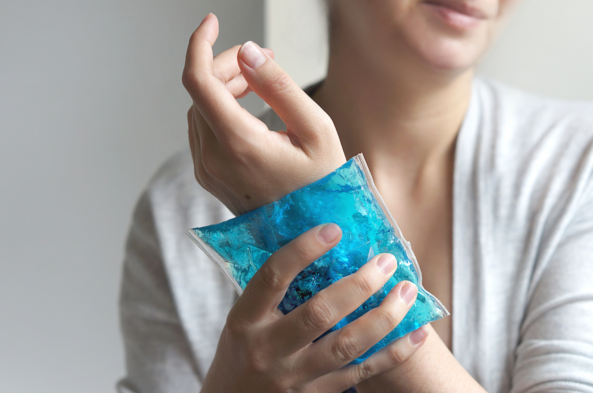 Woman putting ice pack on wrist