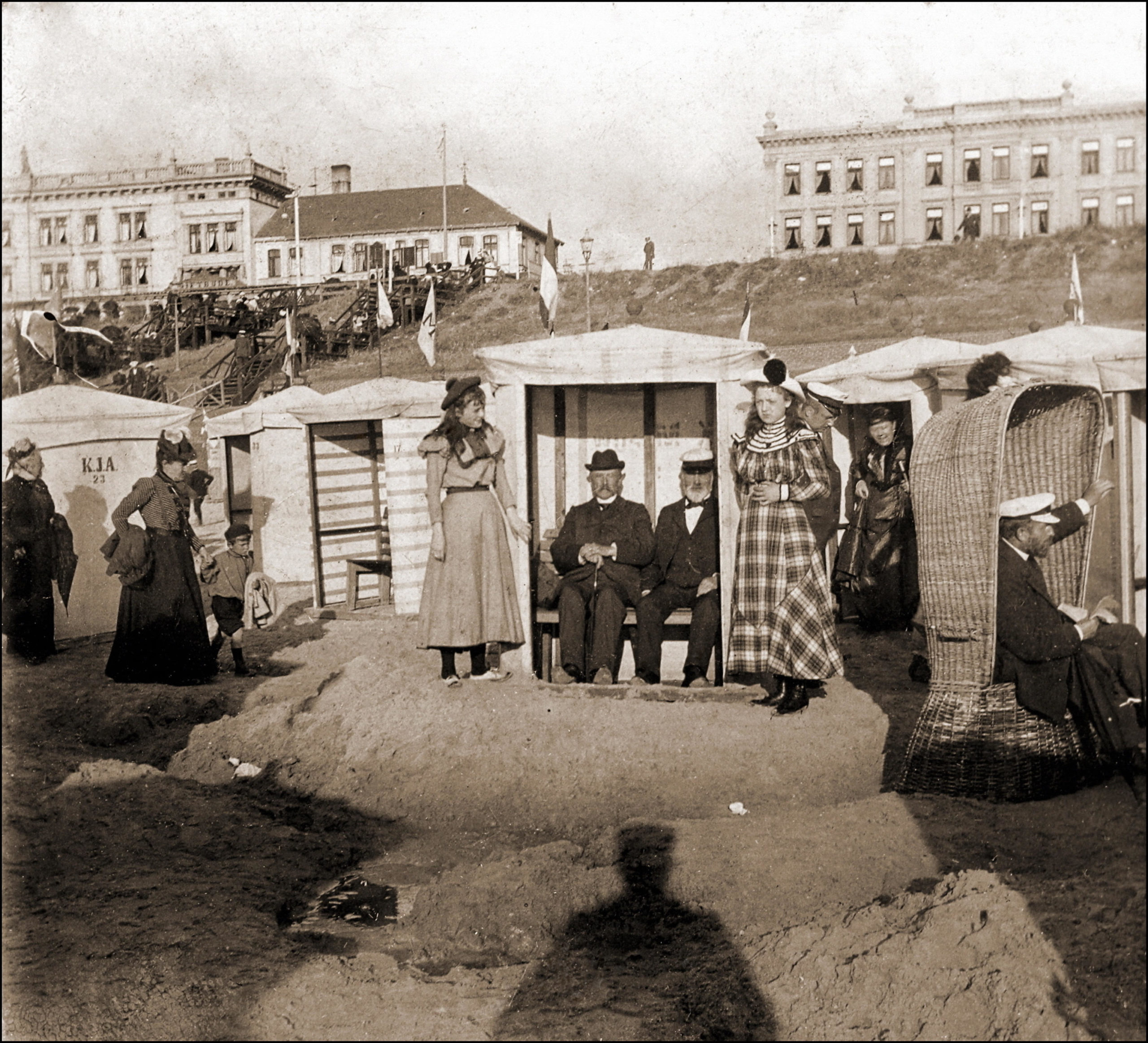 vintage photo of a group of people sitting in beach cabanas