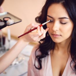 Makeup artist applying eyeshadow on woman