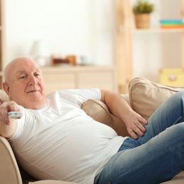Out of shape older white man watching TV