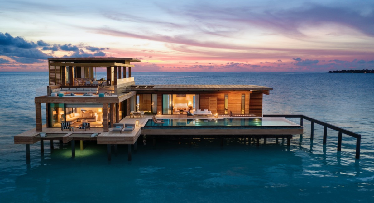 overwater bungalow at dusk at the waldorf astoria in the maldives
