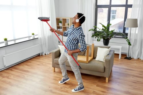 Young man cleaning apartment