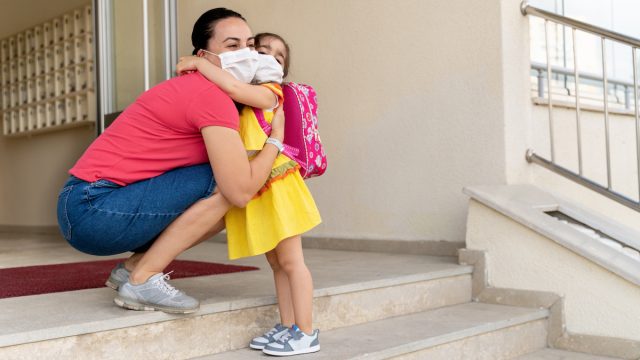 Mother embraces her daughter on the first day of school amid coronavirus