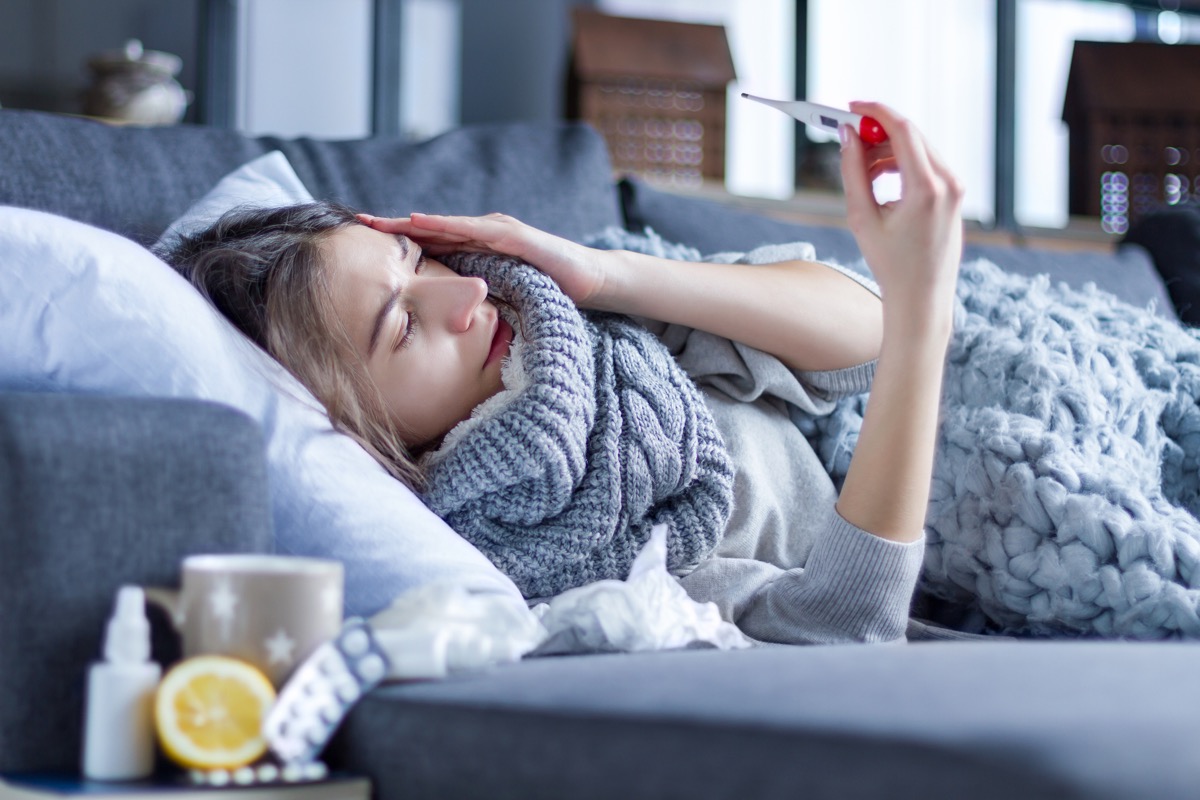 Woman laying on couch with fever and chills
