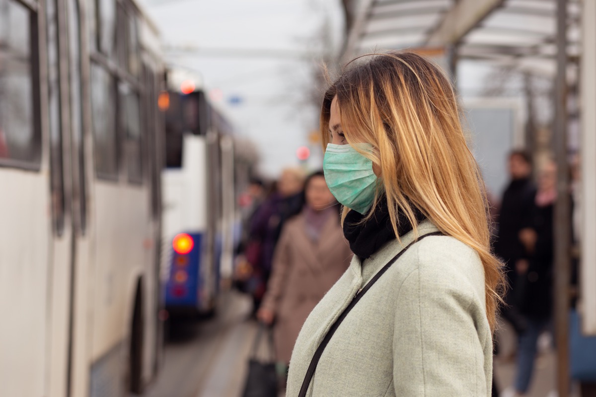 Woman wearing a face mask while waiting for the bus