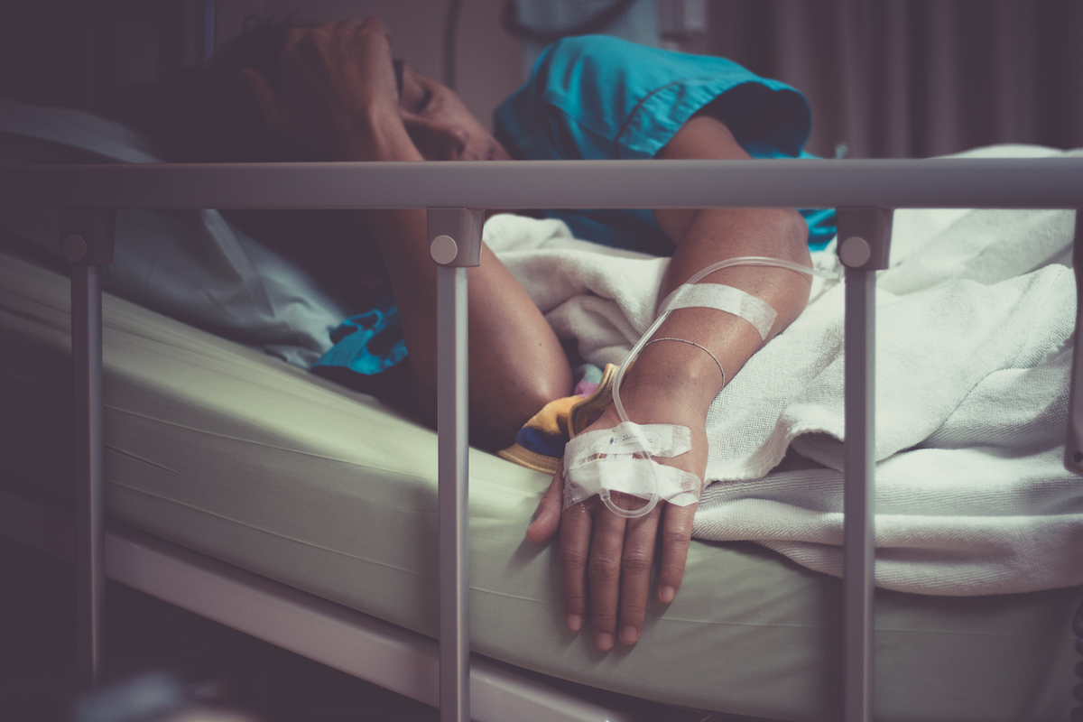 sick woman lying in bed in hospital.